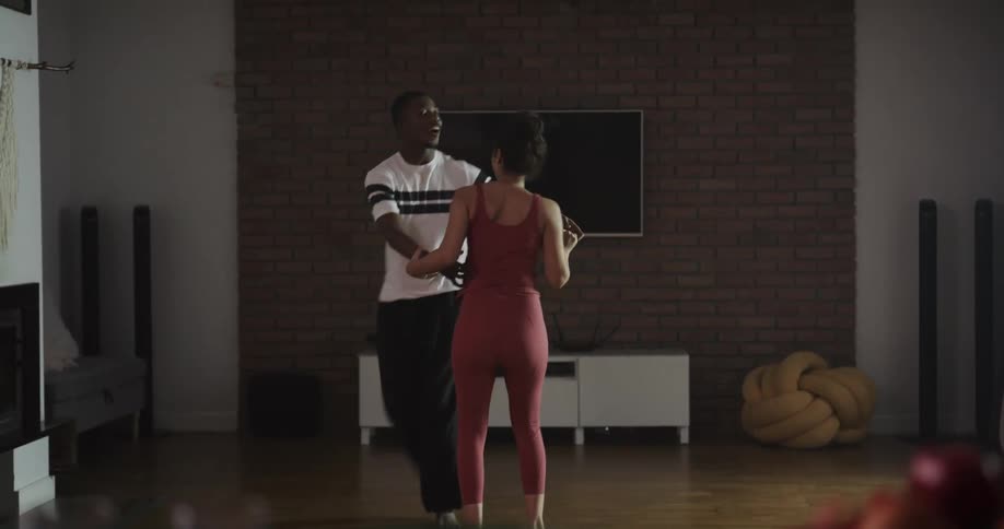 Man and woman are dancing in a room together