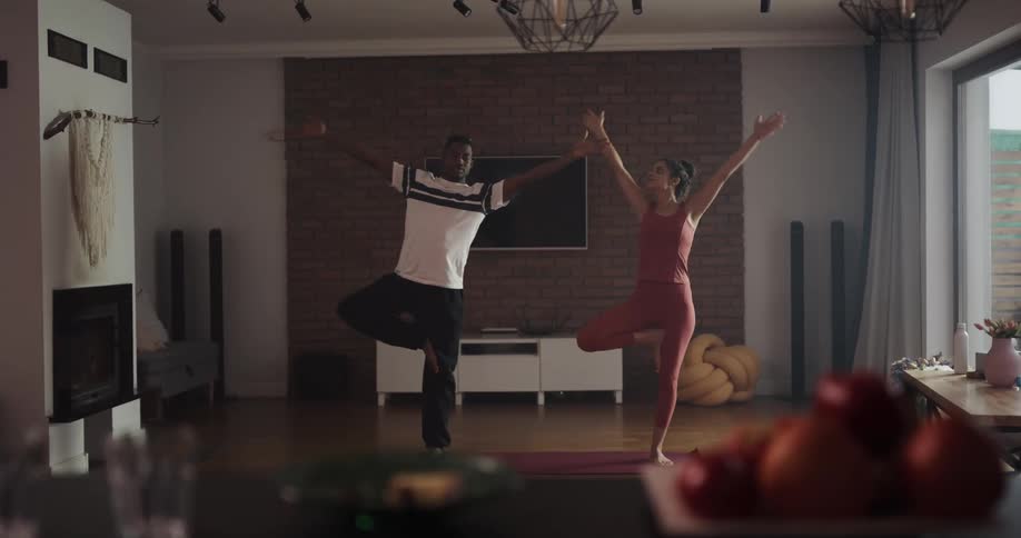 Man and woman are doing yoga together in their living room