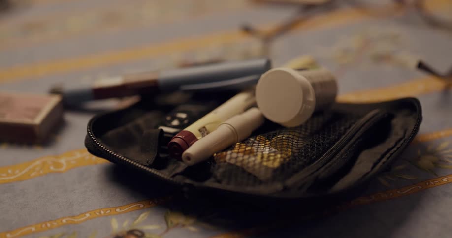 Pens sit atop an unzipped carrying case on a fabric tarp