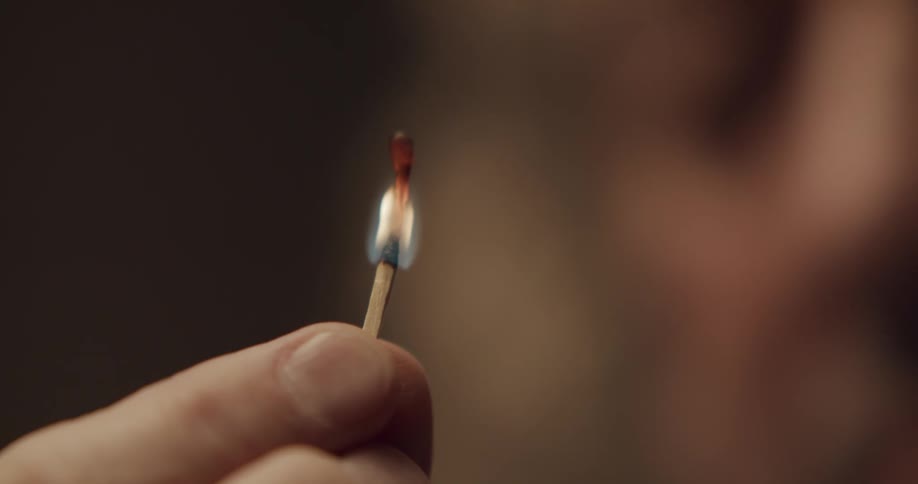 A person is holding a lit match