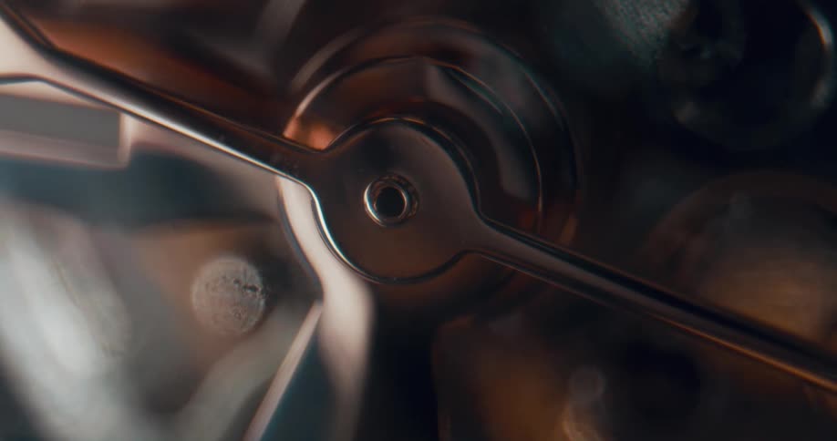 Metallic old copper colored arms on machine slowly tick