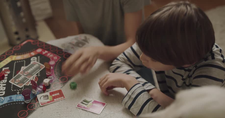 Kids are playing a board game with family