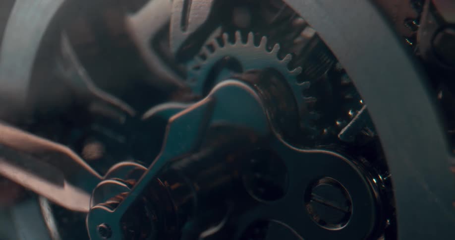 Close up of the moving gears on the functioning mechanism of an analog clock