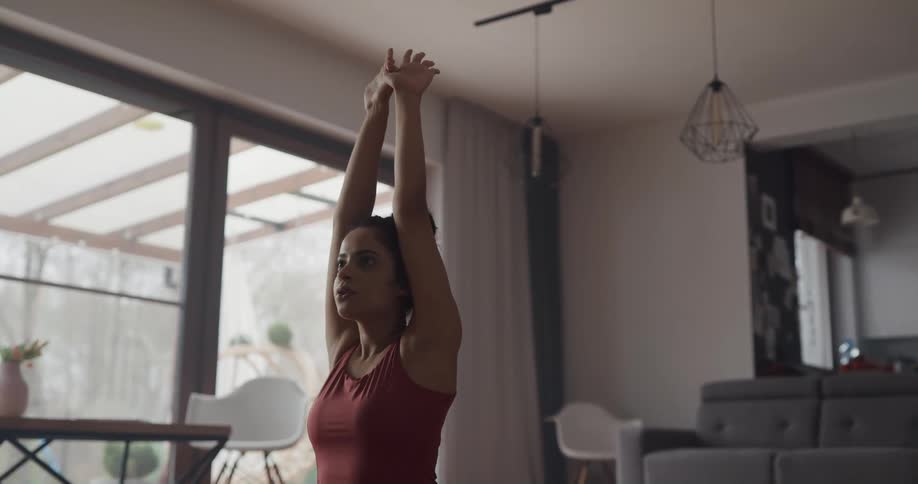 Young woman practices yoga on the living room at home