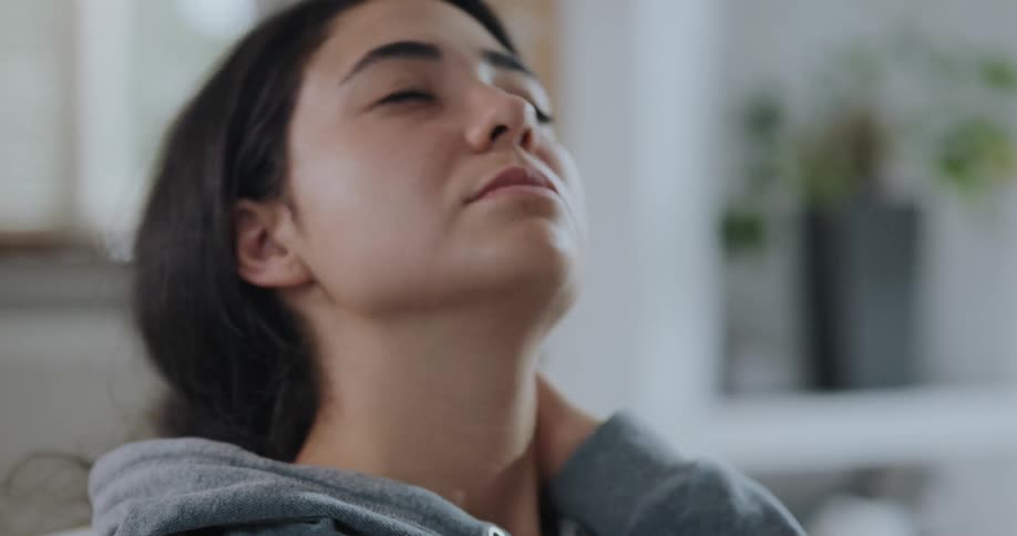 Young sick woman with a headache rubs her head and forehead with her hands