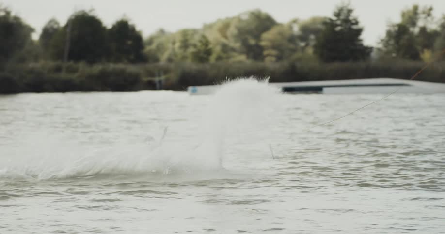 A man spins in the air wake boarding on a lake