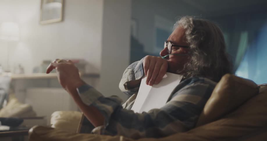 Mature man with long hair wearing a nasal canula talking to his doctor on a video call