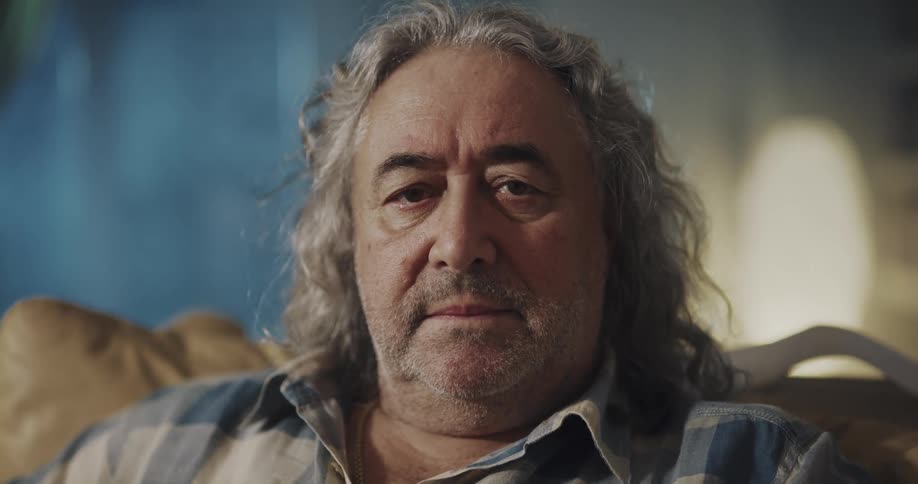A man is sitting in a chair in his living room
