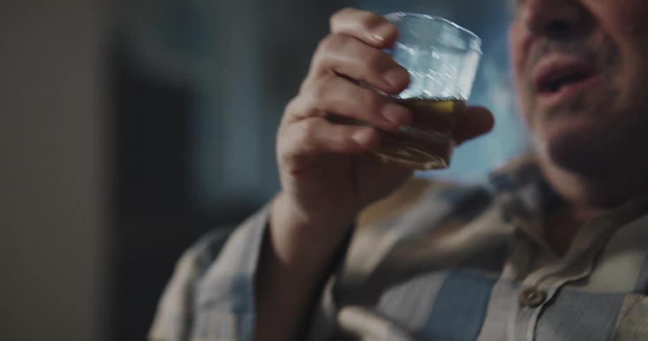 A man is drinking alcoholic beverages at his house