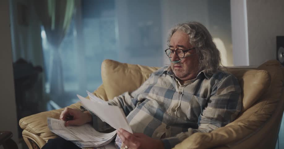 A man is worried as he reads his bills