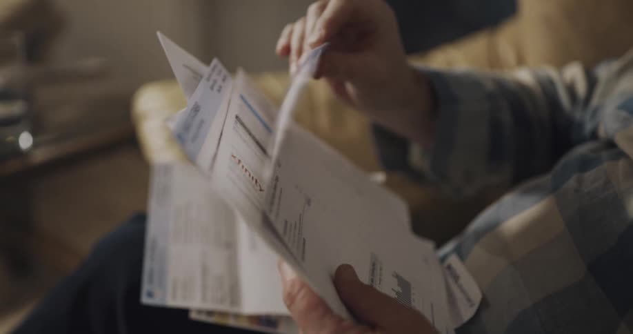 A man is worried while looking at his bills