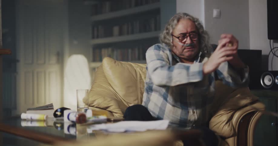 A man looks at his bills and throws them in anger