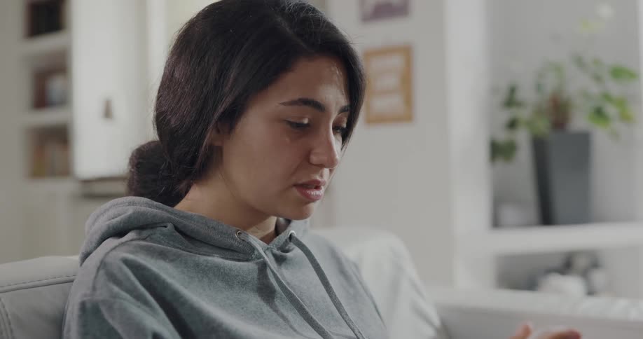 Young woman is sitting on the couch