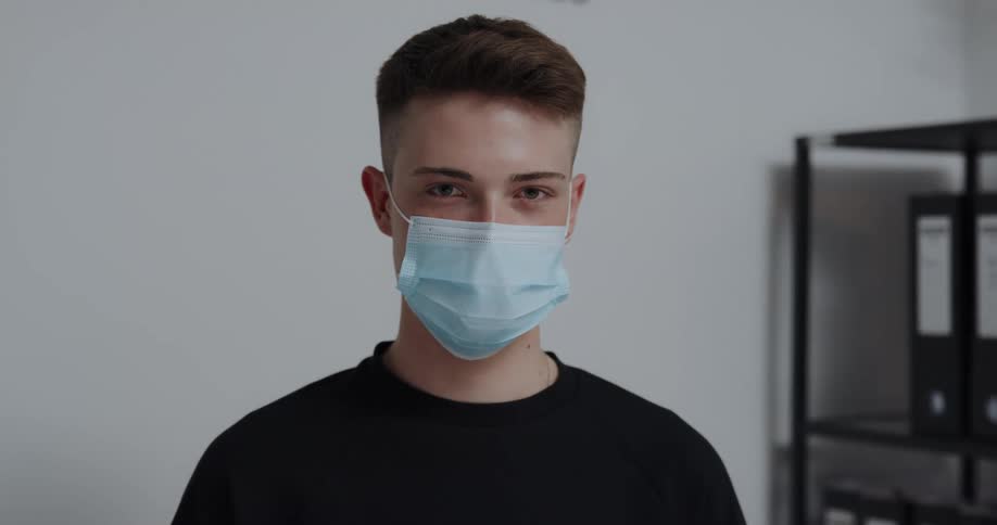 Male teenager wearing a face mask standing looking at the camera