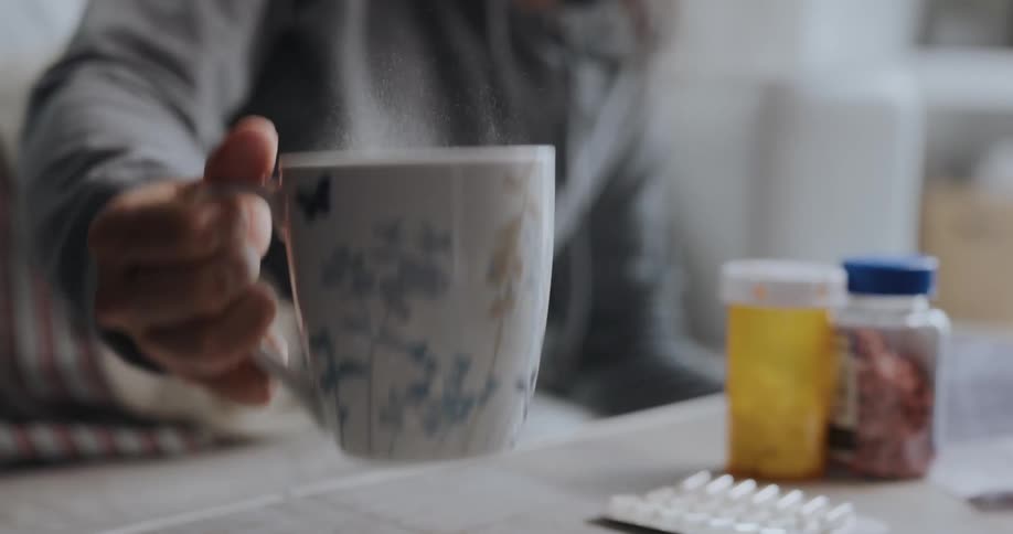 Woman is drinking coffee out of a cup