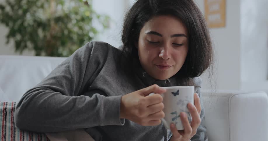 Young woman is drinking a cup of coffee