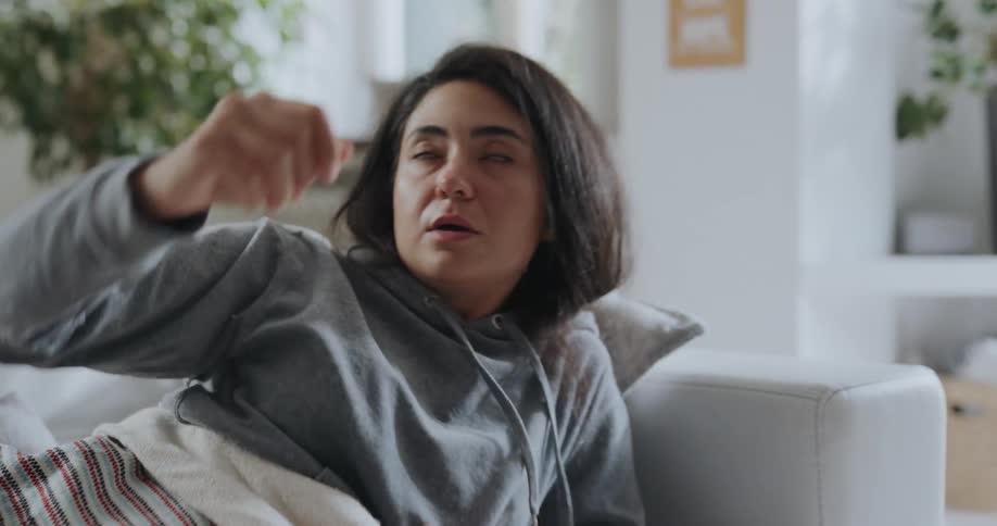 A woman lays down on the couch to rest