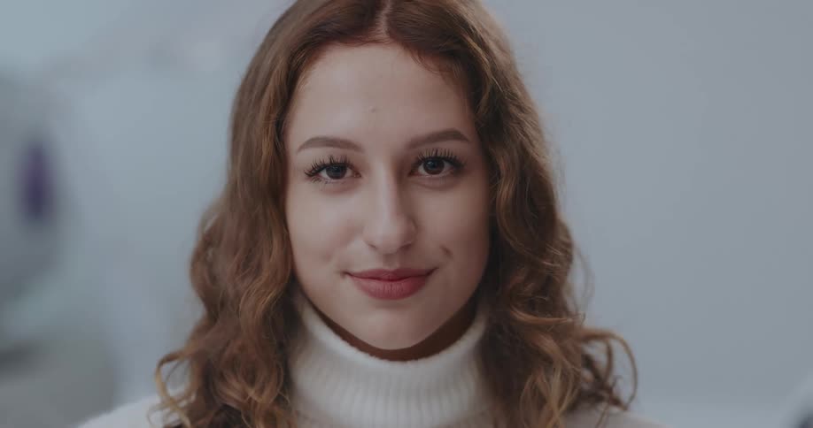 A woman raises her gaze to smile into the camera