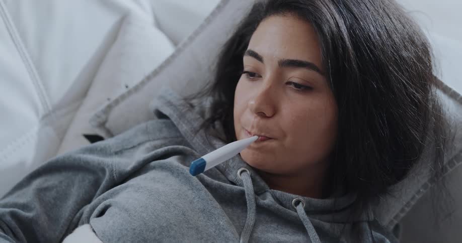Woman is laying down on the couch in her home