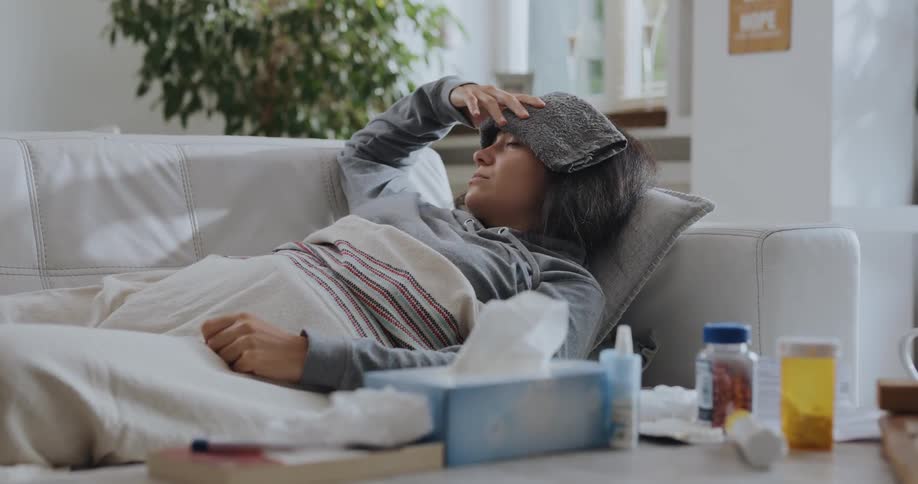 A sick woman laying on a couch