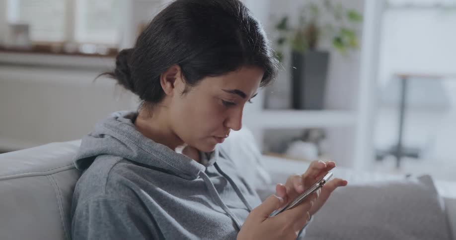 Young woman scrolling through her phone