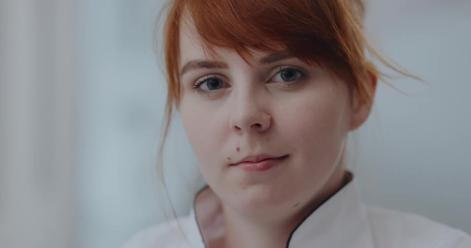 Close up of the face of a redhead woman looking at the camera