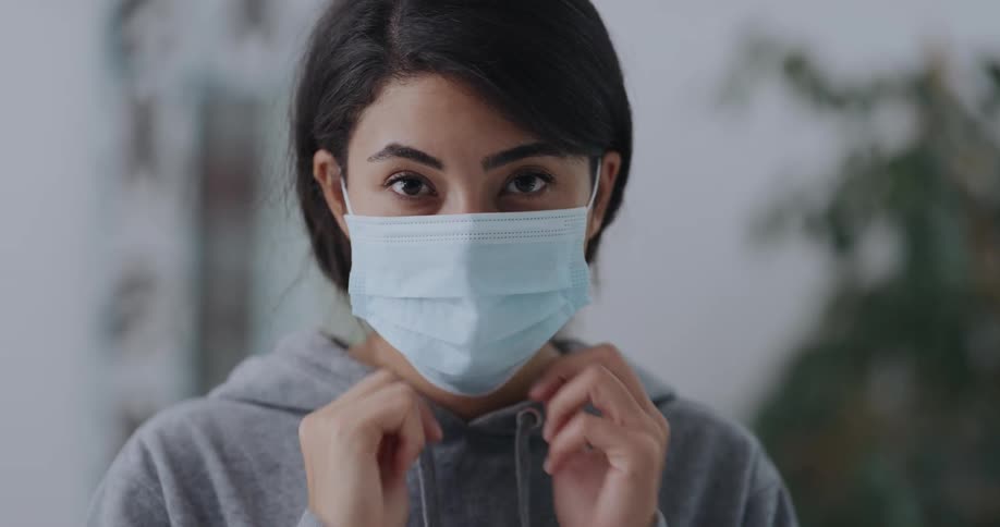 A young girl puts a mask on her face