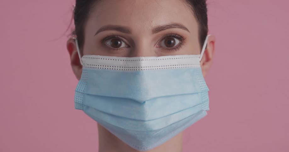 A young woman puts a mask on her face