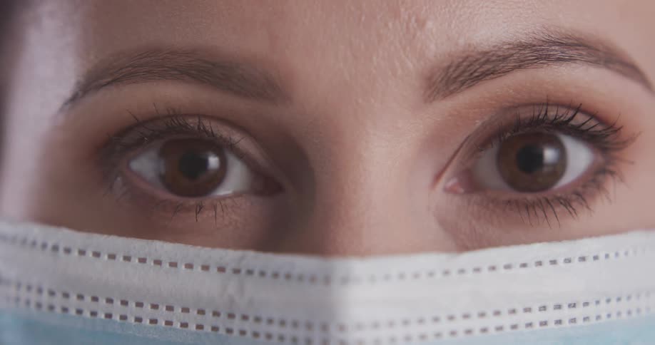 Close up view of a woman wearing a mask is displayed