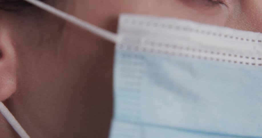 Close up of a woman putting a mask on