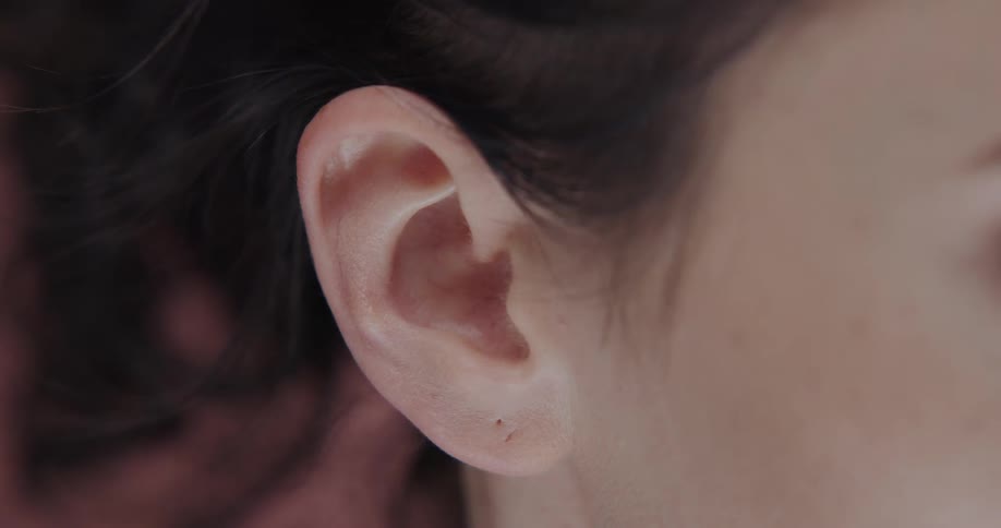 Close up view of a womans ear is displayed on camera