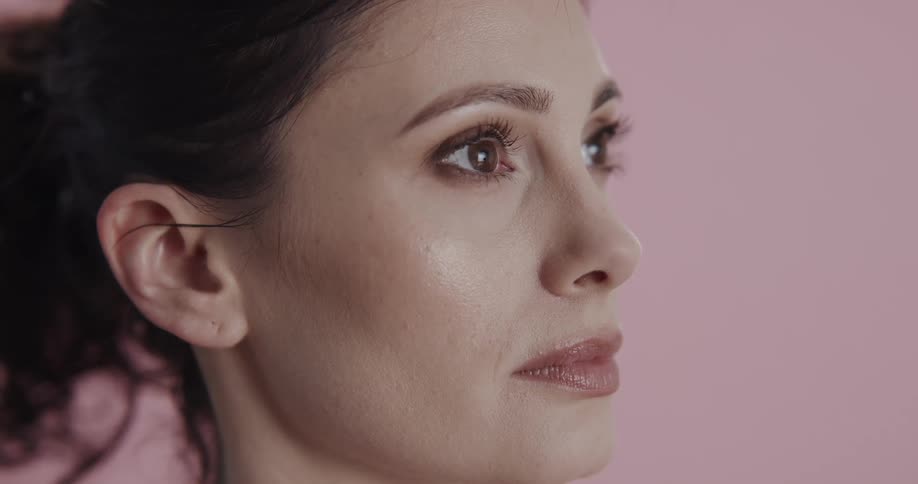 Profile of a female against a pink background
