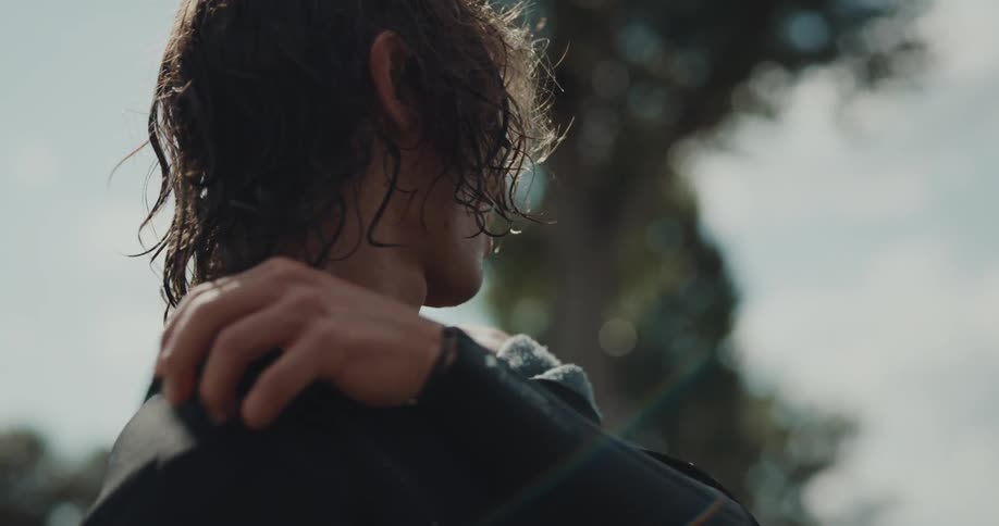 A man is removing his wet suit