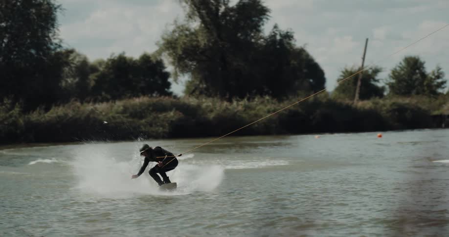 Young man is outside water skiing in the water