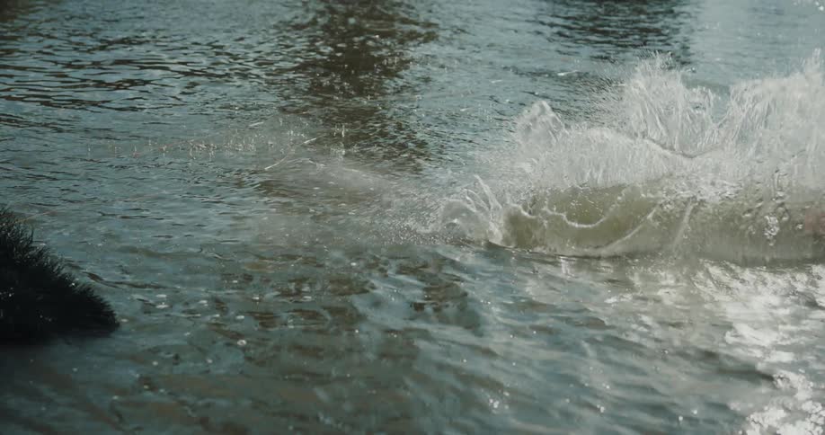 A man jumps on the wakeboard and splashes in the water