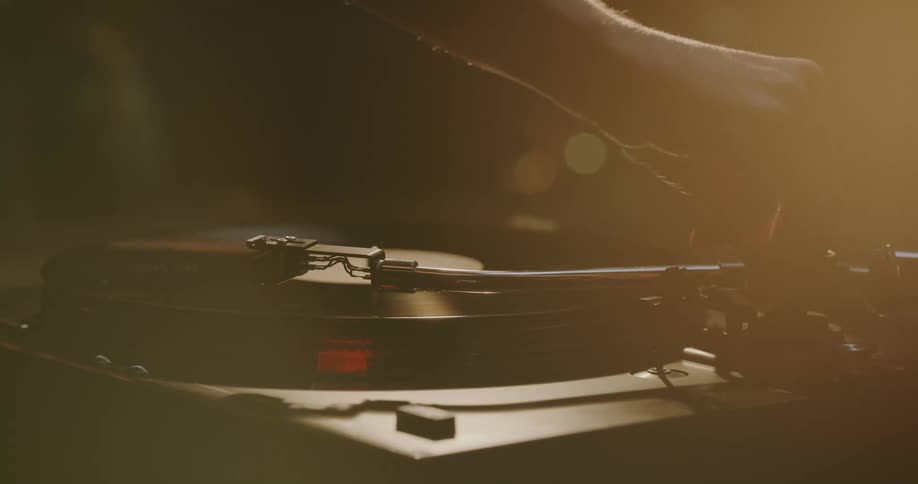 Someone puts a vinyl record on an old turntable and places the needle on the record