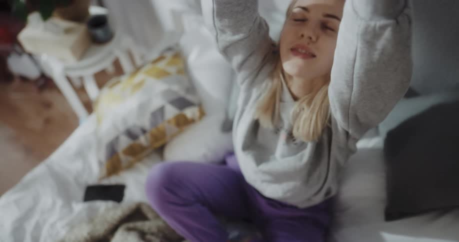 Young woman is stretching on the bed