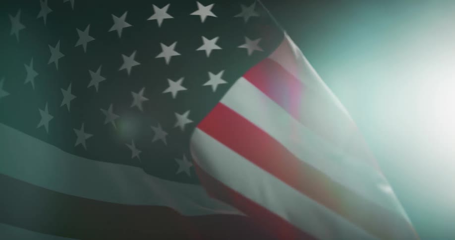 Tight shot of an american flag waving in the wind at night