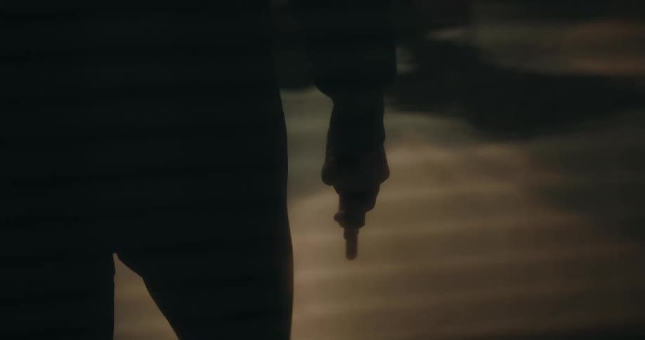 A person holds a gun in the dark room