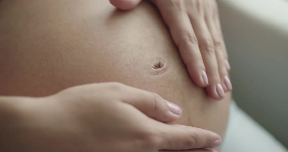 A pregnant woman rubs her stomach