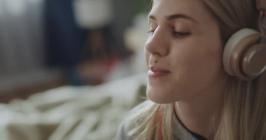 A woman listens to music on headphones