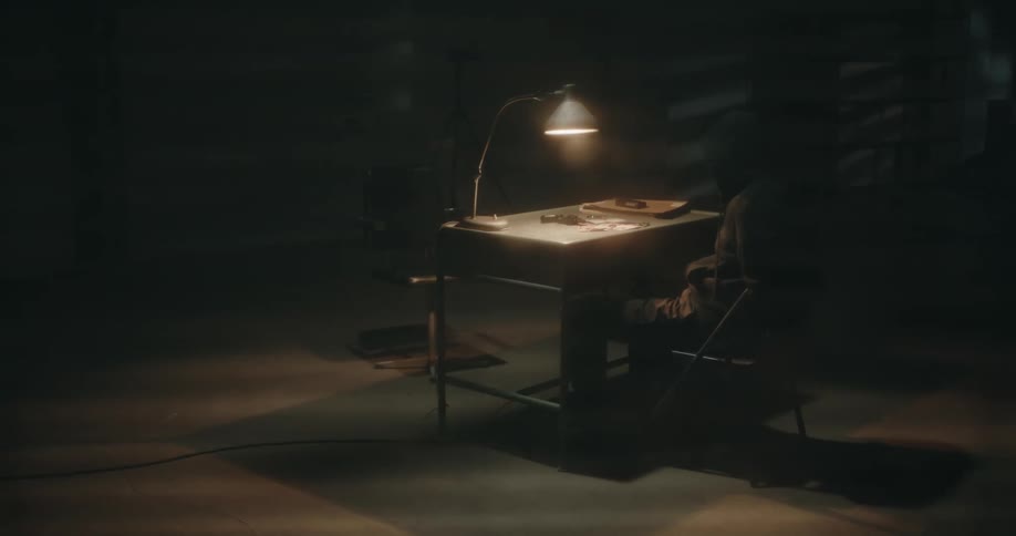 Suspect sitting on an dimly lit interrogation room