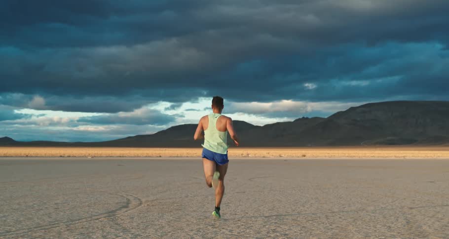 A young man is running in the desert