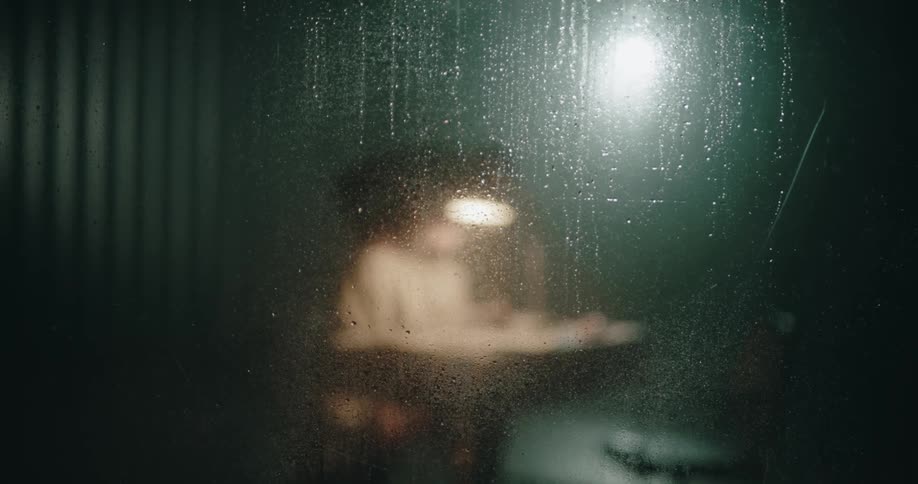 Man aggresively interrogates suspect sitting on a chair inside an interrogation room