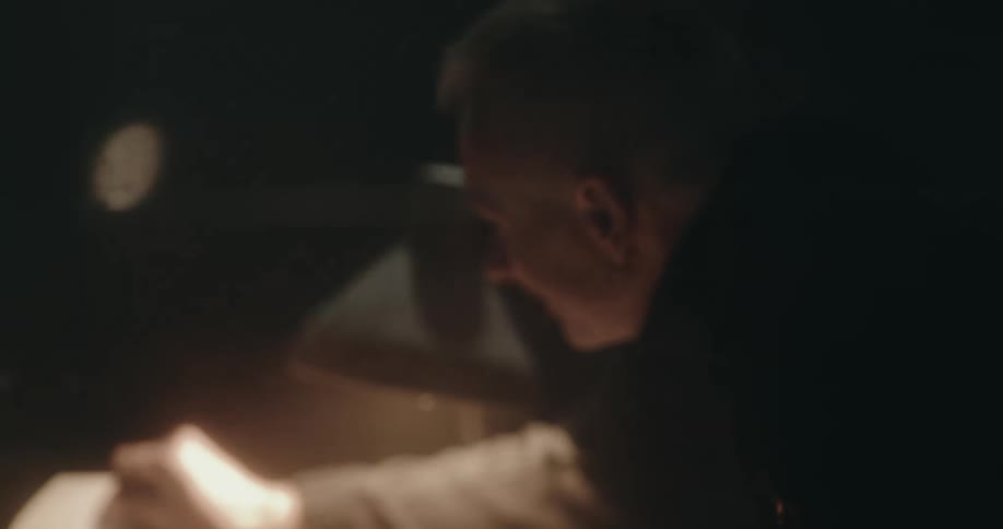 Detective shows pictures to a suspect sitting inside an interrogation room