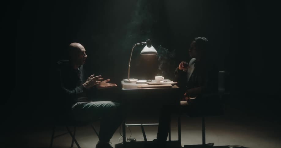 Two people are talking and smoking in a room