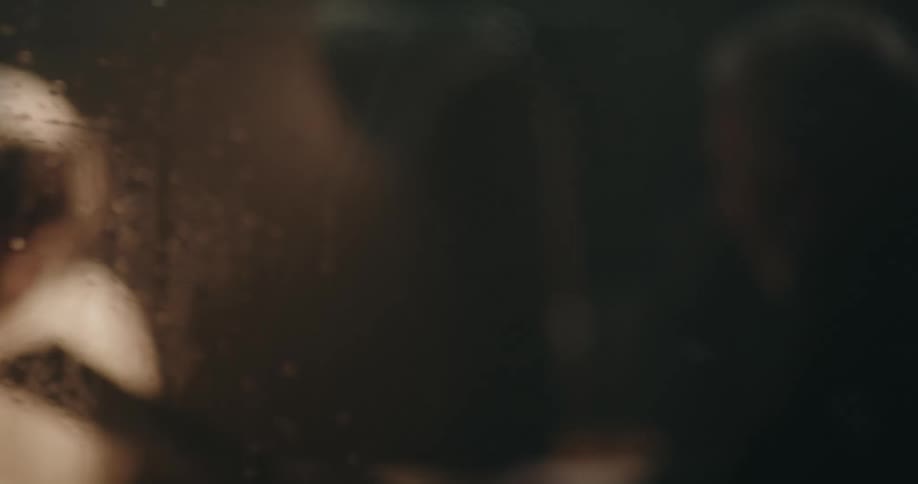 Man being intensely interrogated behind a wet glass
