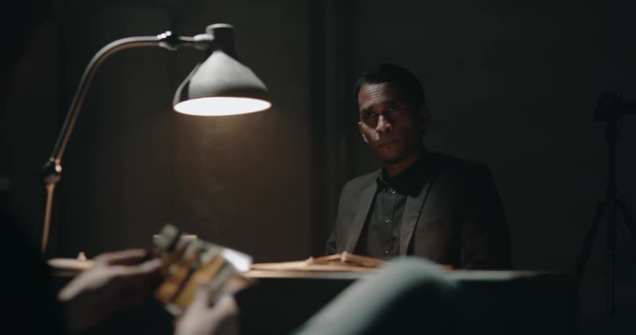 A man interrogating a person in a room