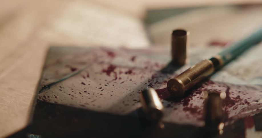 Shell casings sit on top of a photo of a bloody crime scene