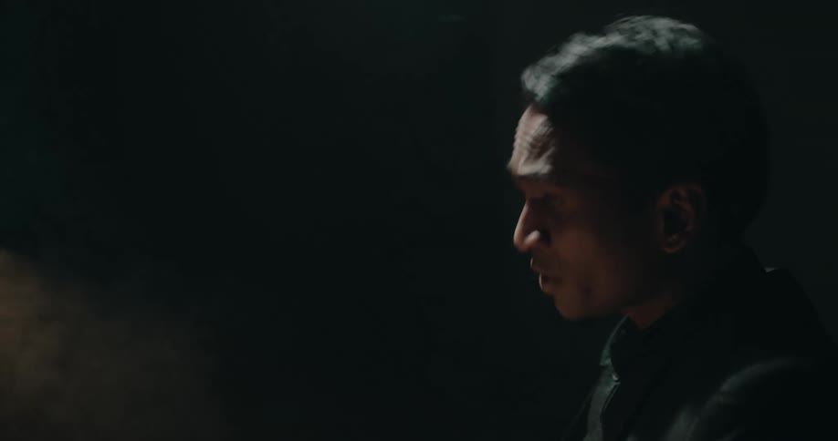 A man is being interrogated in the dark room